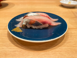 日本の寿司。回転寿司のお皿に乗ったシマアジ握り寿司。
