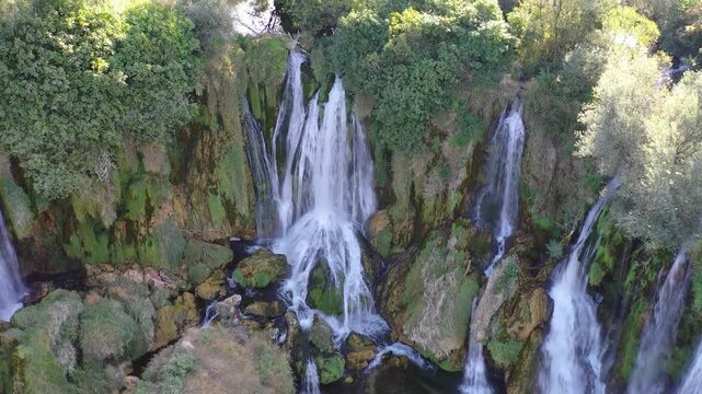 Small waterfall cascading over rocks in forest landscape of Bosnia and Herzegovina