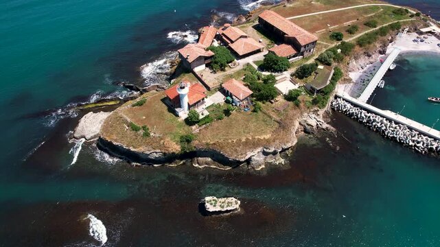 Aerial view of St. Anastasia Island with its buildings, lighthouse, and pier surrounded by the sea, St. Anastasia Island, Burgas, Bulgaria.