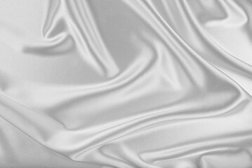 Obraz premium Elegant white silk fabric is draped in a circular ripple pattern.