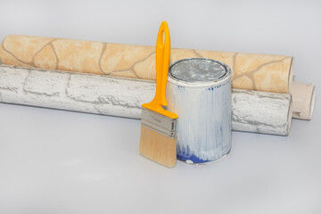 Geometric wallpaper, a can of paint, and a brush on a white background. Concept for a home or apartment renovation