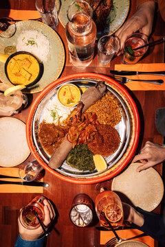 Directly above shot of fresh Ethiopian dish amidst drinks on table at fine dining restaurant