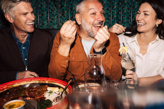 Cheerful man spending leisure time with friends sitting at restaurant