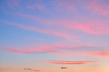 Pink and blue sky with soft clouds at sunset.