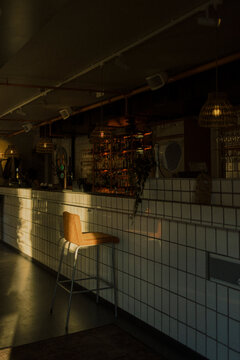 Sunlight falling on chair kept near tiled bar counter in empty restaurant