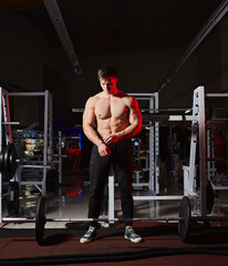 Muscular bodybuilder preparing to lift heavy barbell in a gym.