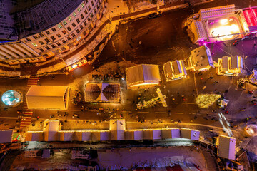 Aerial drone view of a festive Christmas market with a Ferris wheel at night.