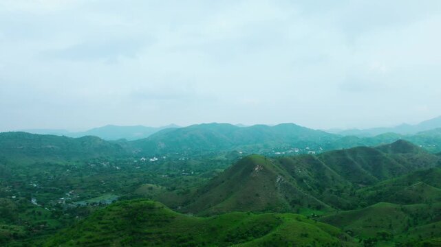 4K aerial view of Rayta Hills at Udaipur, Rajasthan, India. Green mountains and cloudy sky during monsoon season. Travel and holidays background. Lush green hills of Aravalli Range. Protect ecosystem 