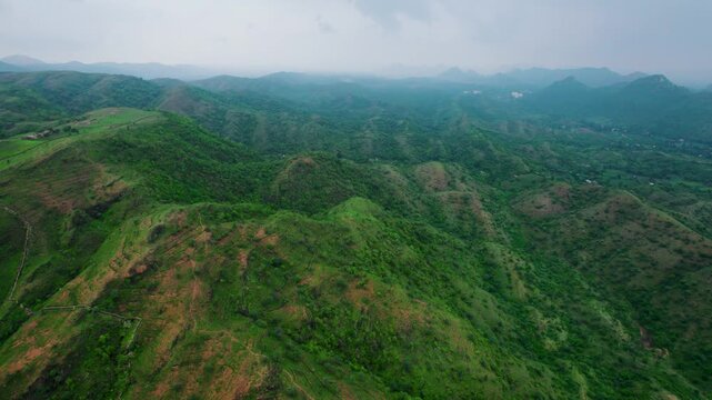 4K aerial view of Rayta Hills at Udaipur, Rajasthan, India. Green mountains and cloudy sky during monsoon season. Travel and holidays background. Lush green hills of Aravalli Range. Protect ecology co