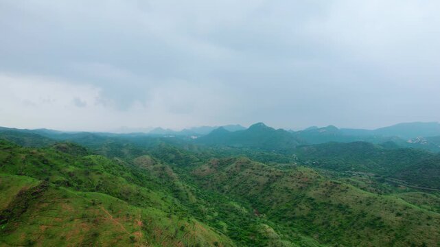 4K Aerial landscape of green Aravalli range and dark clouds in sky as seen from Rayta village in Udaipur, Rajasthan, India. Aravalli hills during monsoon season. Nature landscape. 