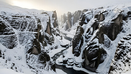 snowy winter canyon landscape with frozen river below dramatic cliffs covered in snow with light falling
