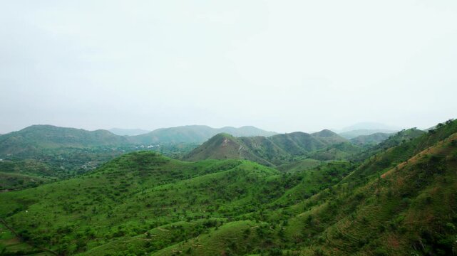 4K Aerial shot of lush green Aravalli hills at Rayta, Rajasthan, India. Green landscape during monsoon season and dark storm clouds in sky. Travel and holidays background. Lush green hills of Aravalli