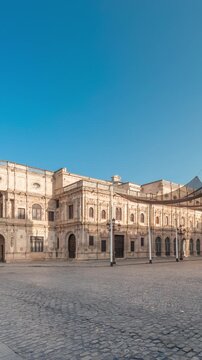 Panorama showing morning timelapse of the Town Hall in Plaza de San Francisco, Seville. Casa Consistorial, Plateresque architecture surrounded by traditional Andalusian buildings under a blue sky