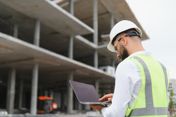 Engineer man managing construction site with laptop