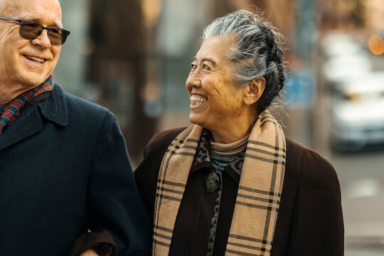 Smiling senior woman enjoying leisure time with man at street