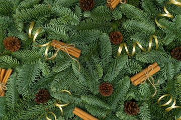 Evergreen Fir Branches with Cones, Cinnamon and Golden Ribbons Christmas Flat Lay Background