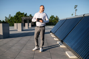 Man using technology to inspect rooftop solar installation