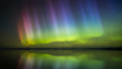 Aurora borealis display in the night sky over water  natural phenomenon