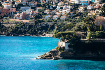 Coastal view of Roquebrune-Cap-Martin with turquoise Mediterranean Sea, rocky shoreline and hillside residential buildings