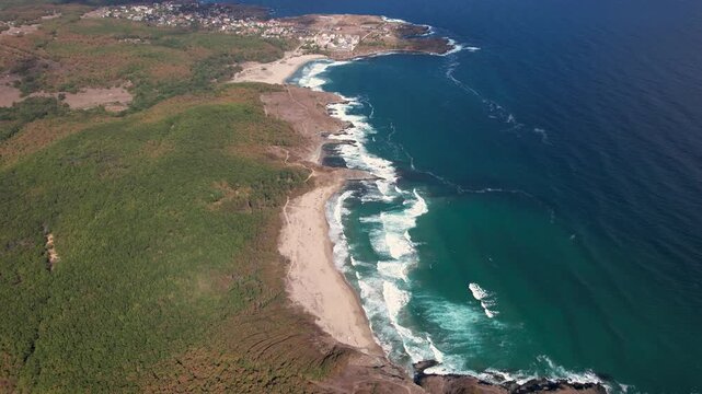 Aerial view of the rugged coastline where lush green forests meet the turquoise waters of Butamyata Beach, creating a stunning contrast of colors, Sinemorets, Bulgaria.