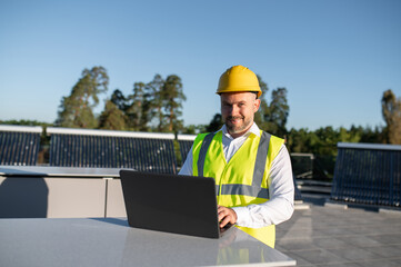 Engineer checking renewable energy installation using laptop on rooftop
