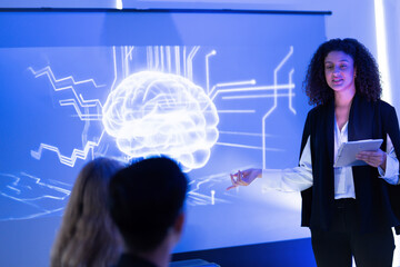 Professional woman presents digital brain concept during technology seminar at night in modern conference room