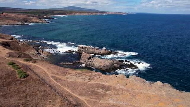 Aerial view of the rugged, rocky coast meeting the deep blue sea, showcasing the dramatic contrast between the land and water, Sinemorets, Bulgaria.