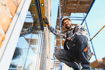 Construction worker checking window level on building
