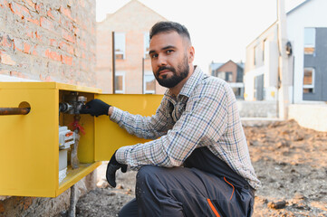 Utility technician installing gas meter at new property