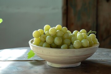 Fototapeta premium Bunch of ripe green grapes presented in a rustic ceramic bowl, placed on a weathered wooden table, creating a still life composition