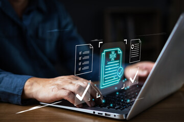 Business hand typing on laptop with hologram of digital document and AI automation checklist. Smart technology for paperless data management and electronic verification workflow concept.