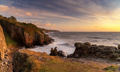 panorama sunset seascape of the Bornholm coast below Hammershus with stormy seas and the Camel Heads and lion Heads rock formations