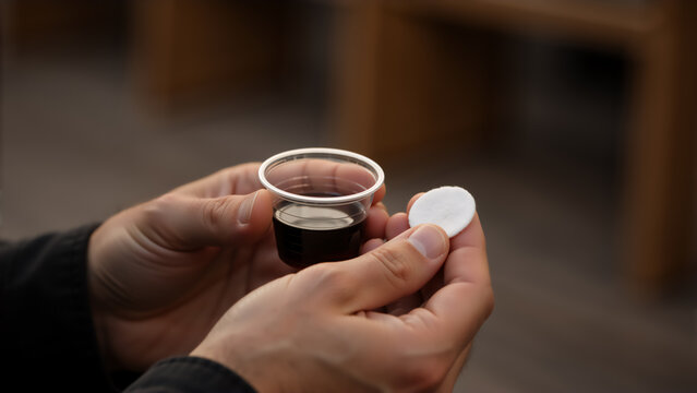 Close-up of a person holding the holy communion elements. Man participating in the Eucharist with bread and wine. Christian faith and sacrament concept