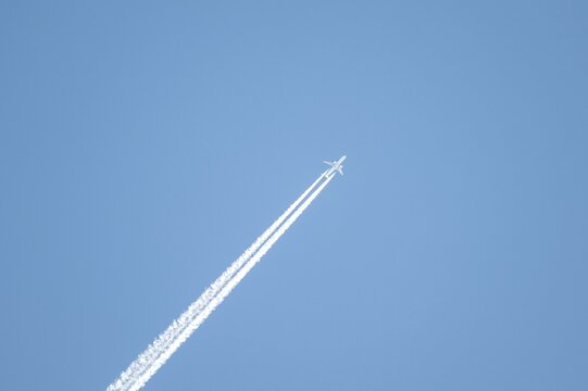 Airplane against blue sky with kondes strips, Tyrol, Austria