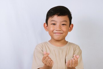 Smiling Asian boy photographed in a studio with white background, representing happiness, childhood, and positive lifestyle themes.