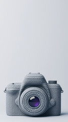 Creative artistic grey wool vintage camera with button lens. This nostalgic craft style object represents photography and hobby on plain studio background with copy space