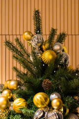 Christmas tree with gold festive ornaments inside room interior