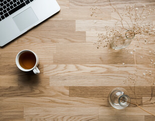 Tranquil top view of clean minimalist wooden desk workspace. Flat lay background shows laptop and cup of coffee for peaceful morning work session at home office