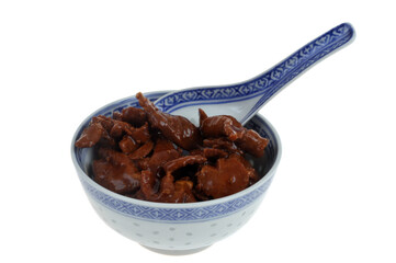 Bol de porc au caramel avec une cuill&egrave;re en gros plan isol&eacute; sur fond blanc