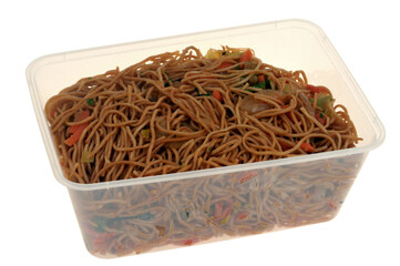 Barquette en plastique de nouilles saut&eacute;es en gros plan isol&eacute;e sur fond blanc