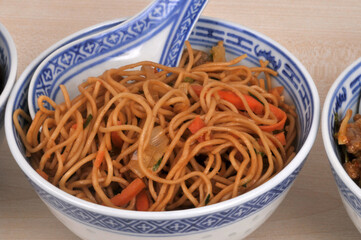 Bol de nouilles saut&eacute;es avec une cuill&egrave;re en gros plan