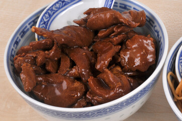 Porc au caramel servi dans un bol avec une cuill&egrave;re en gros plan