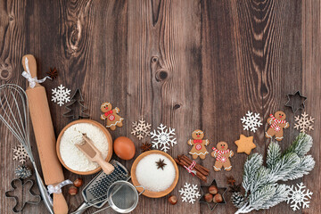 Festive Christmas background. Gingerbread baking preparation on a rustic wooden table during the holiday season