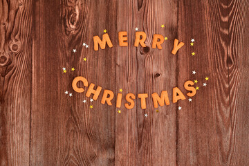 Merry Christmas cookies and festive stars on dark wooden background. Top view, copy space. Christmas Baking background.
