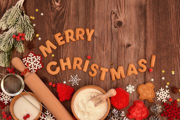 Holiday baking activity with festive decorations and tools for holiday preparation on a wooden background.
