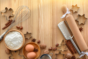 Holiday baking activity with festive decorations and tools for holiday preparation on a wooden background.