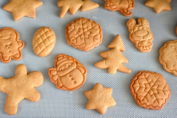 Gingerbread cookies in the shape of festive Christmas ornaments fresh from the modern oven. Making Christmas gingerbread cookies