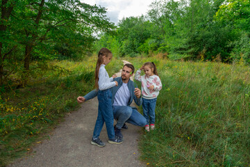 Fototapeta premium Father and children have fun, laugh and enjoy nature outdoors.