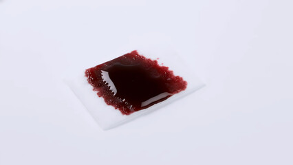 Red stain on white medical gauze pad isolated on white background