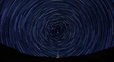 Celestial sphere rotation visible as concentric white streaks across a dark night sky above a silhouetted horizon